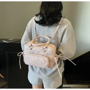 Detail of pink bow backpack showing its premium leather texture and stylish zipper compartments