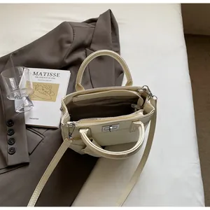 Top view of cream white handbag showing multi-compartment interior and silver lock