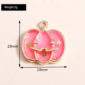 Macro detail of pink enamel pumpkin pendant with gold stars and measurement info