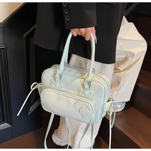 Detail of mint green crossbody bag with three decorative 3D bows and zipper compartments