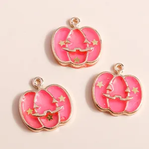 Close-up of pink enamel pumpkin pendants with star and smile details for DIY jewelry