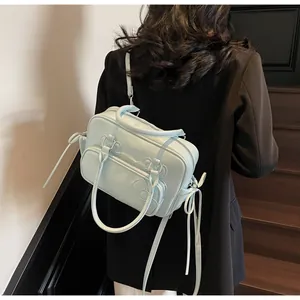 Light blue multi-purpose women's bag with bow detail shown on back in indoor setting
