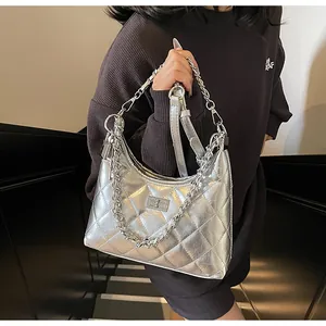 Detailed shot of a silver quilted chain bag with a metallic turn-lock and leather strap