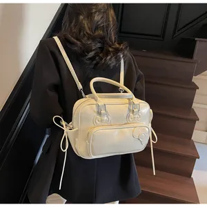 Detail view of cream pillow backpack with bow accents shown on a model against stairs