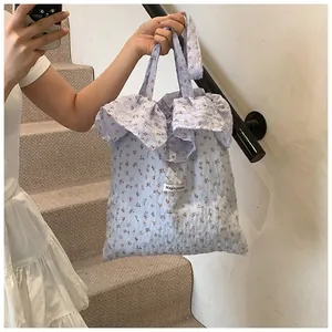 Close-up of floral canvas tote bag featuring ruffled edges and Magic Pocket label