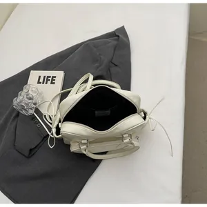 Detail of off-white pillow bag interior and double zippers on minimalist handbag