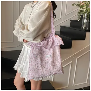 Detail of floral canvas tote showing ruffled strap design and delicate flower patterns