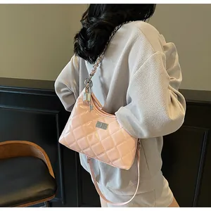 Detail of pink quilted patent leather bag with silver chain strap and metal lock pendant