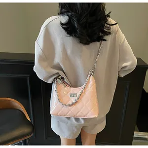 Pink quilted faux leather shoulder bag with silver chain strap shown on model shoulder