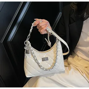 Detail of white quilted patent leather bag with silver twist lock and chain strap