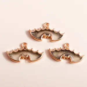 Macro detail of bat-shaped resin pendants with rose gold alloy frame and glitter