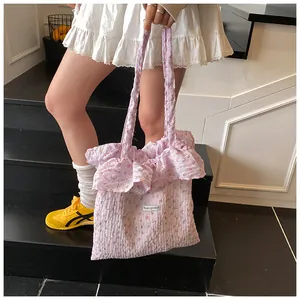 Detailed view of ruffle edge and red floral pattern on light purple canvas tote bag