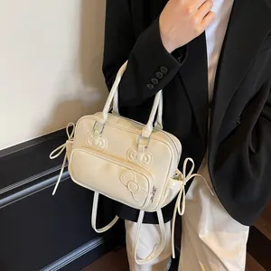 Cream leather pillow bag featuring three decorative bows and detachable shoulder strap