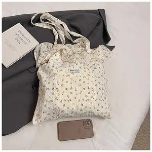 Detailed close-up of floral canvas tote bag with Magic Pocket label and ruffled trim