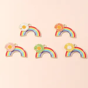 Five rainbow daisy alloy pendants with colorful enamel flowers on pink background