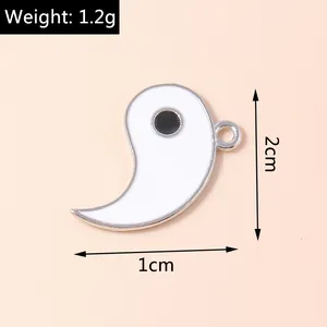 Detail of Yin Yang enamel pendant with dimensions 2x1cm and weight 1.2g on pink background