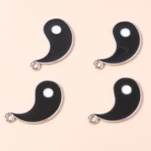 Macro detail of black and white Yin Yang enamel pendants with silver metal plating for DIY