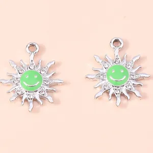 Detailed view of silver flower charms with green enamel smiley faces and small rhinestones