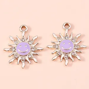 Detail of golden sun pendants with purple enamel smiling faces and crystal rhinestones
