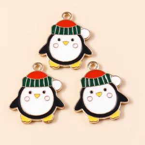 Detailansicht von drei Emaille-Pinguin-Anhängern mit Weihnachtsmützen für DIY-Schmuck