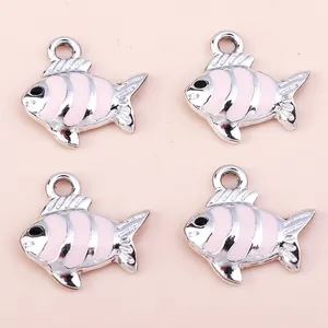 Detail of four silver-toned metal fish pendants with pink enamel stripes for DIY jewelry making
