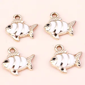 Set of four gold-plated alloy fish charms with white enamel coating and metal rings