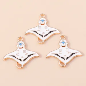 Close-up of three DIY tropical stingray alloy charms with white and gold enamel finish