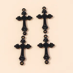 Gros plan de pendentifs croix gothiques noir mat avec relief floral et doubles boucles
