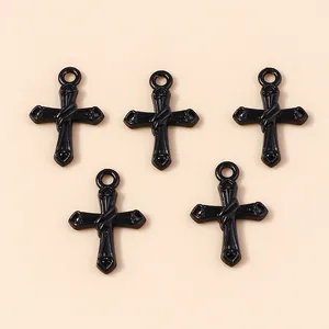 Detailed view of five black alloy cross pendants with smooth finish for DIY jewelry crafts