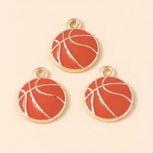 Gros plan de breloques de basket en émail orange avec détails dorés pour bijoux DIY