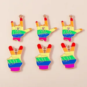 Dettaglio di sei ciondoli in smalto arcobaleno con gesti di amore e pace e bordi dorati