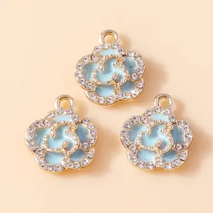Detail of light blue enamel rose pendants with sparkling crystals and gold plating