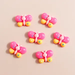 Flat lay of colorful butterfly resin charms for DIY phone case crafts and jewelry making