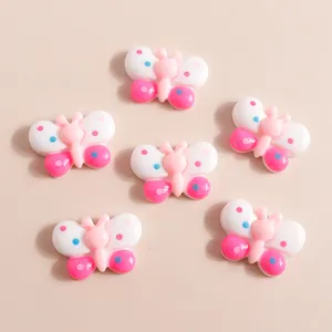 Detail of colorful resin butterfly charms with polka dots for DIY phone case crafts