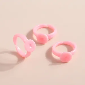 Detailed view of pink adjustable plastic ring bases with flat pads for DIY jewelry making