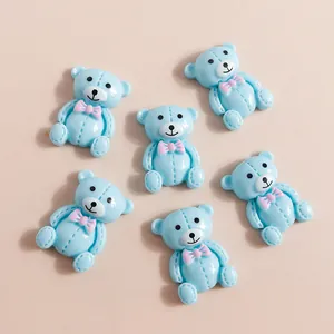 Gros plan d'oursons en résine bleu clair avec nœuds roses pour loisirs créatifs