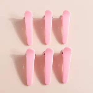Set di sei fermagli per capelli in resina rosa disposti ordinatamente per acconciature DIY