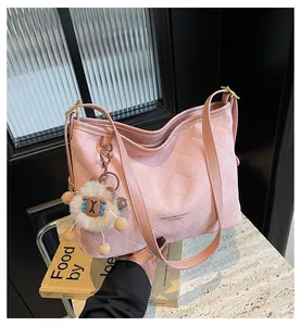 Détail du sac à bandoulière matelassé rose avec breloque mouton et logo en cuir