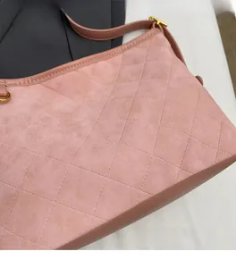 Détail du sac cabas rose en daim matelassé montrant la texture et la boucle dorée