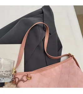 Détail du cabas en velours rose avec surpiqûres losanges, boucle en métal et pompon brun
