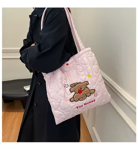 Borsa tote rosa trapuntata a cuori con ricamo di cucciolo di peluche sulla modella