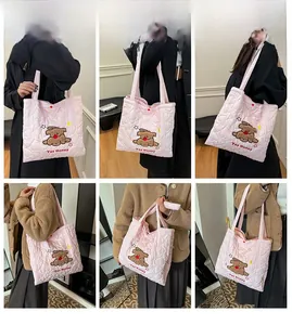 Dettaglio borsa shopper trapuntata rosa con ricamo di cane indossata da una modella