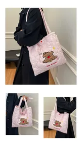 Dettaglio della borsa tote rosa trapuntata a cuore con ricamo a forma di cucciolo morbido