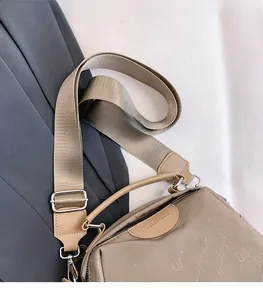 Gros plan sur la bandoulière réglable en nylon et la boucle de la sacoche kaki