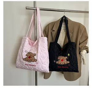 Dettaglio delle borse tote trapuntate a cuore rosa e nere con ricamo a forma di cucciolo