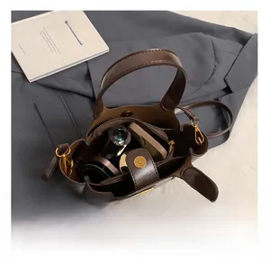 Detail view of brown bucket bag interior featuring magnetic closure and zipper compartment