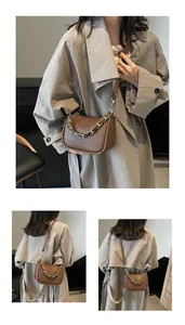 Détail du sac bandoulière en cuir grainé marron avec grosse chaîne en métal doré