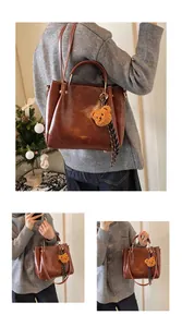 Detail view of brown PU tote bag with gold metal handles and cute bear charm decoration