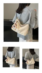 Détail du sac hobo avec motif matelassé et accessoire porte-clés poupée en peluche