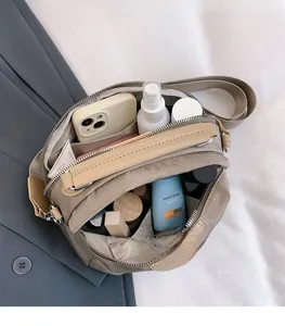 Vue de dessus de l'intérieur spacieux du sac bandoulière en nylon kaki à double zip